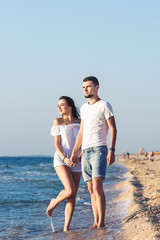 Young happy couple posing by the sea.