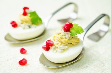 Blue cheese deviled eggs with pomegranate and fresh parsley leaves