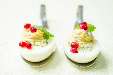 Blue cheese deviled eggs with pomegranate and fresh parsley leaves