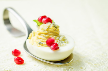 Blue cheese deviled eggs with pomegranate and fresh parsley leaves