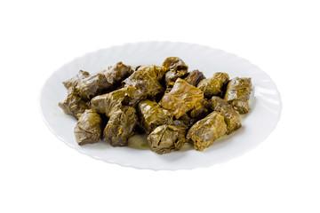 Dolma stuffed meat in grape vine leaves on white plate isolated on white background.
