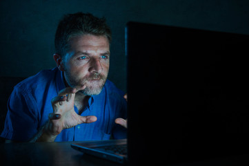 young aroused and excited sex addict man watching porn mobile online in laptop computer light night at home in pornography addiction internet pornographic content