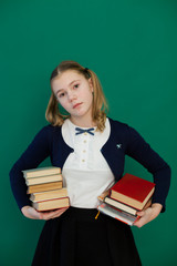 schoolgirl girl during a lesson at the Blackboard with books