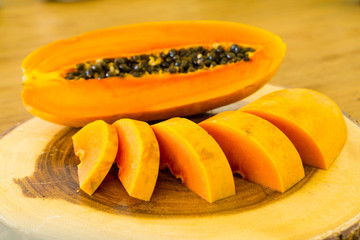 cutting papaya on wooden table