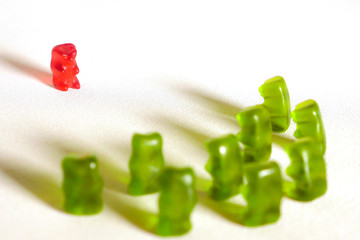 sweet candy gummy teddy bears representing group of students or work colleagues bullying and...
