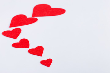 Red hearts of different sizes on a white background. Harvesting cards for Valentine's Day. Place for text, copy space.