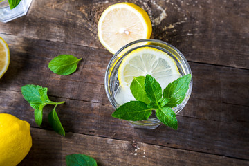 Fototapeta na wymiar Top view of lemon water with fresh lemons and mint