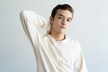 Confident teen boy touching neck. Attractive guy relaxing. Teen boy portrait concept. Isolated...