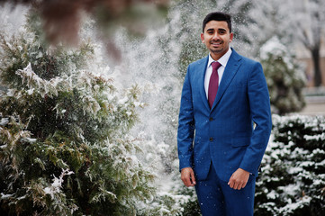 Elegant indian fashionable man model on suit posed at winter day.