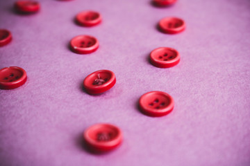 Beautiful texture with many round pink buttons for sewing, needlework. Copy space. Flat lay. Pink, purple background