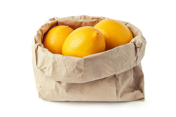 Lemons in brown paper grocery bag isolated on white background