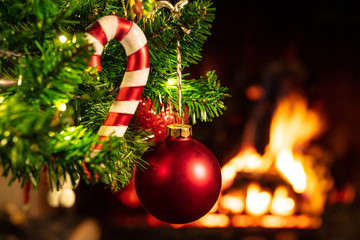 Christmas tree close up on blurred burning fireplace background