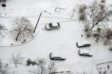 Cars in parking are covered snow