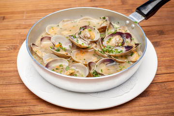 Mussels in a frying pan on a wooden background