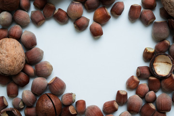 Heart shaped frame made of macadamia nuts, hazelnut, walnut on the white background