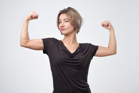 Happy Young European Woman Showing Her Strong Hand. I Can Do It Concept