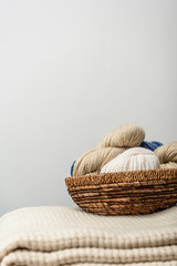 Obraz premium close up view of yarn clews in wicker basket on grey backdrop