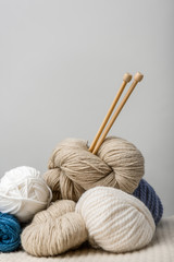 Fototapeta na wymiar close up view of knitting needles in yarn clews on grey background