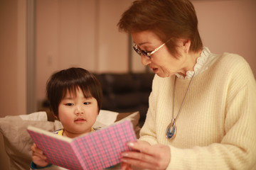 絵本を読む男の子とシニア女性