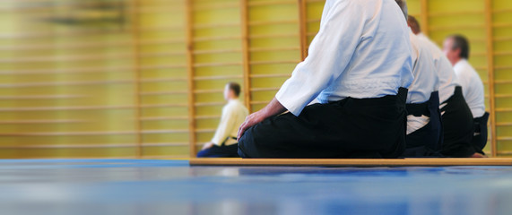 Aikido background. Meditation before passing the exam. Wrestlers in white kimano and black hakama....