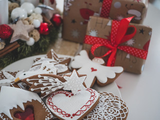 Christmas gingerbreads, candles, and Christmas bell. In background Christmas tree.