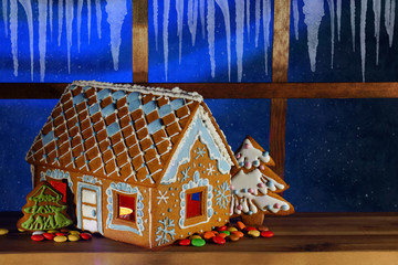 Gingerbread house on the background of the night window. Christmas gingerbread house. Night sky...