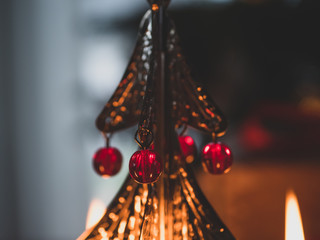 Christmas candles and Christmas bell. In background Christmas tree.