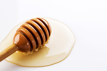 Honey and honey dipper on white background