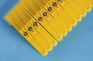 Yellow clothes pins isolated on blue background