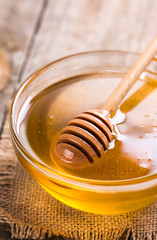Fresh honey with stick in glass bowl 