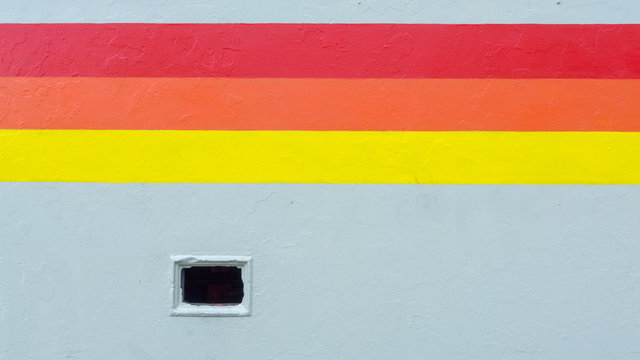 A tricolor stripe runs along a wall