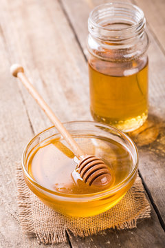 Honey in glass bowl on wooden table