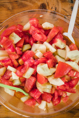 Tomato and cucumber salad in bowl on the wooden table