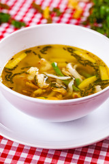 Soup with vegetables and seafood in white bowl. Close up