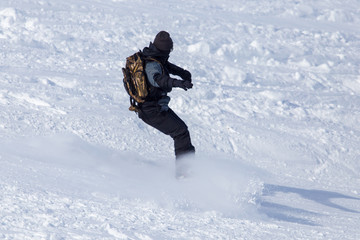 A man snowboarding a mountain in the snow in winter