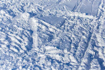 Fototapeta na wymiar Traces of skiers on white snow in the mountains