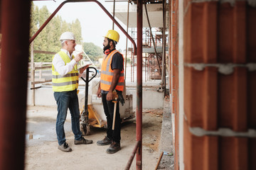 Fototapeta na wymiar Portrait Of Happy Construction Site Supervisor Talking To Manual Worker