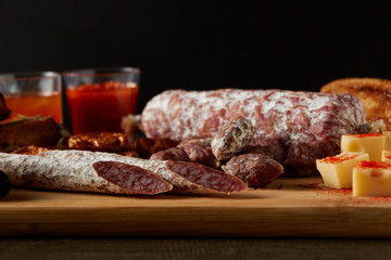 dried sausage, spiced cheese on wooden board
