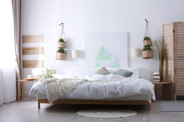 Fototapeta na wymiar Stylish apartment with large comfortable bed. Room interior