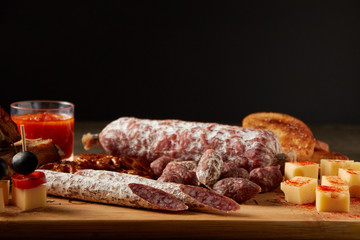 dried sausage, spiced cheese on wooden board