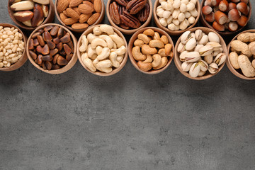 Flat lay composition with organic nuts and space for text on grey background, top view. Snack mix