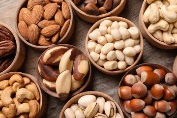 Flat lay composition with organic nuts on wooden background, top view. Snack mix