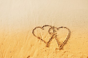 Plakat Valentine's Day concept, two heart shape writing on sand beach.