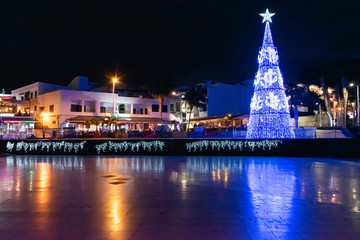 Night view of old town and Christmas tree with tourists in Puerto del Carmen, Canary Islands, Spain