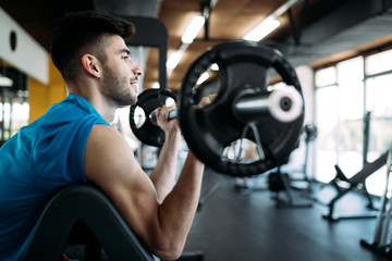 Fototapeta na wymiar Fit man exercising at the gym on a machine