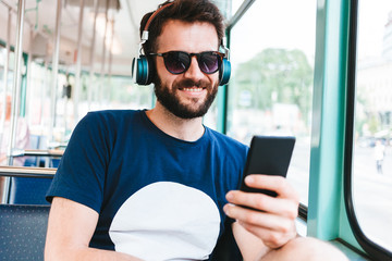 Young man riding in public transport listening to the music