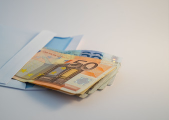 Various € Euro banknotes in a white envelope 