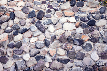 Natural colorful pebbles wall on beach in summer