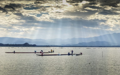 Fototapeta na wymiar Beautiful lake view evening of many small fishing boat floating in the lake with colorful of sun rays in the sky background, sunset at Kwan Phayao, Phayao Province, northern of Thailand.