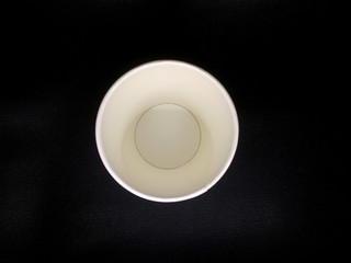 Top view of paper coffee cup on black background